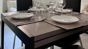 A dining area with a table set for four, including plates, glasses, and cutlery. - Heart Of Eagle - Dwelling in the historic center with private courtyard (L'Aquila)
