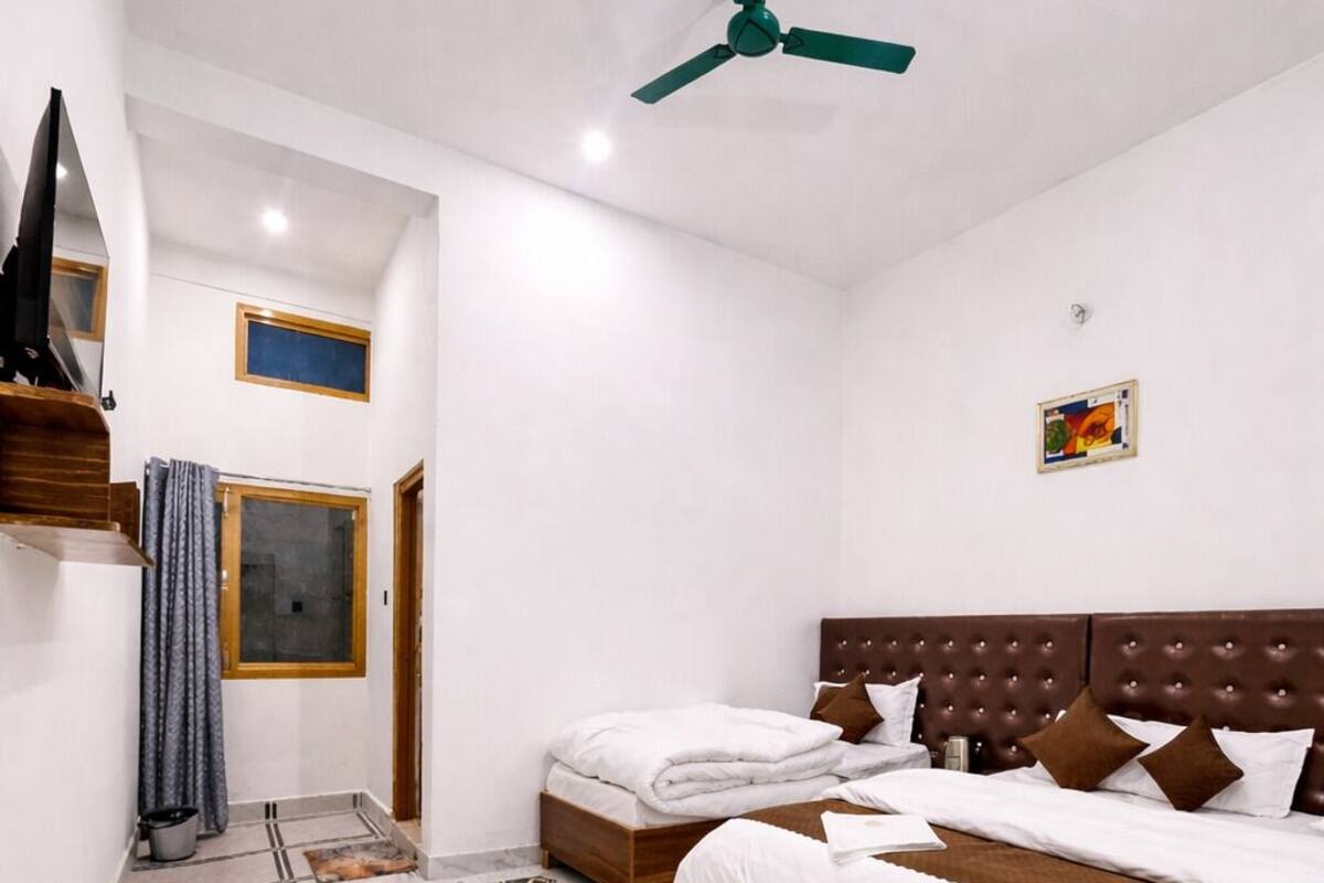 Un dormitorio con cama, ventilador de techo, ventana y puerta.