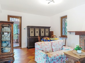 A living room with a sofa, a cabinet, and a window.