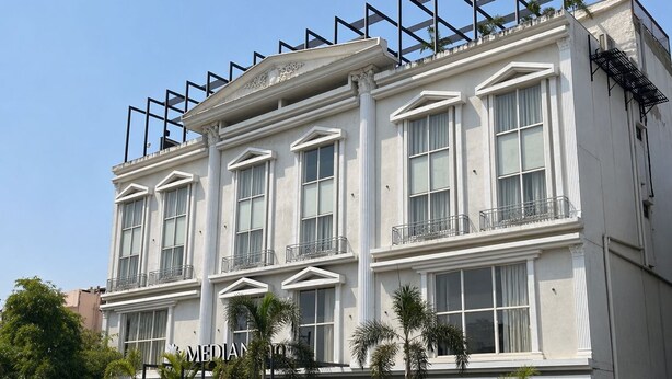 A multi-story building with a classical architectural style, featuring large windows and a balcony on the upper floor.