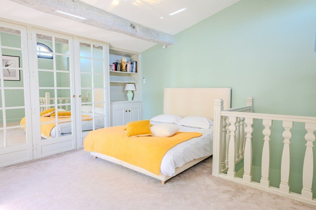 A bedroom with a bed, a wardrobe, and a nightstand.