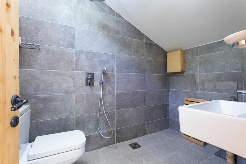 Et moderne badeværelse med toilet, bruser og badekar.