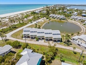 Ein Küstenresort mit Strandvillen, einem zentral gelegenen Pool und einer Straße zum Strand.