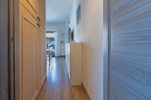 A hallway with wooden flooring, white walls, and a door leading to a room with a view. - Bright and welcoming 50 square meters apartment, perfect for two people, located on the second floor of a building without an elevator.The property is located in a quiet area of ​​Quartu Sant'Elena, well-served by amenities such as restaurants, bars, (Quartu Sant'Elena)