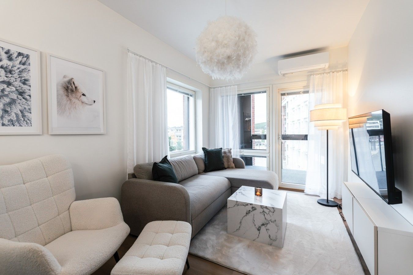 Ein modernes Wohnzimmer mit einer Couch, einem Sessel und einem Couchtisch.