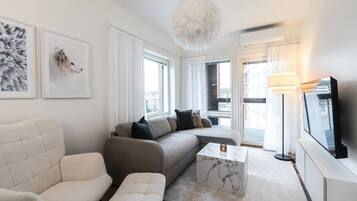 Ein modernes Wohnzimmer mit einer Couch, einem Sessel und einem Couchtisch.