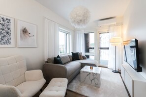 Ein modernes Wohnzimmer mit einer Couch, einem Sessel und einem Couchtisch.