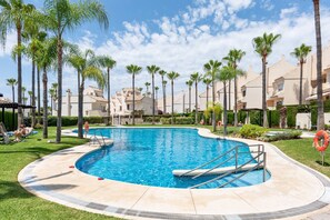 A swimming pool surrounded by palm trees and buildings. - 3318 Casa Sunshine (Marbella)