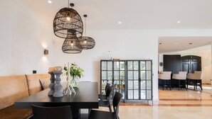 A modern dining area with a wooden table, black chairs, and a black cabinet with glass doors. - 3310 Villa Flores (Marbella)