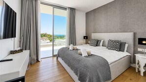 Een moderne slaapkamer met een groot bed, een televisie en uitzicht op de omgeving.