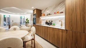 Una cucina moderna con mobili in legno, un piano di lavoro in marmo e un'area pranzo con un tavolo rotondo e sedie.