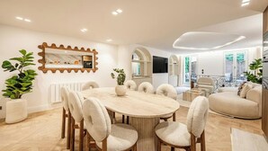 Una sala da pranzo moderna con un tavolo rotondo, sedie e uno specchio a parete.