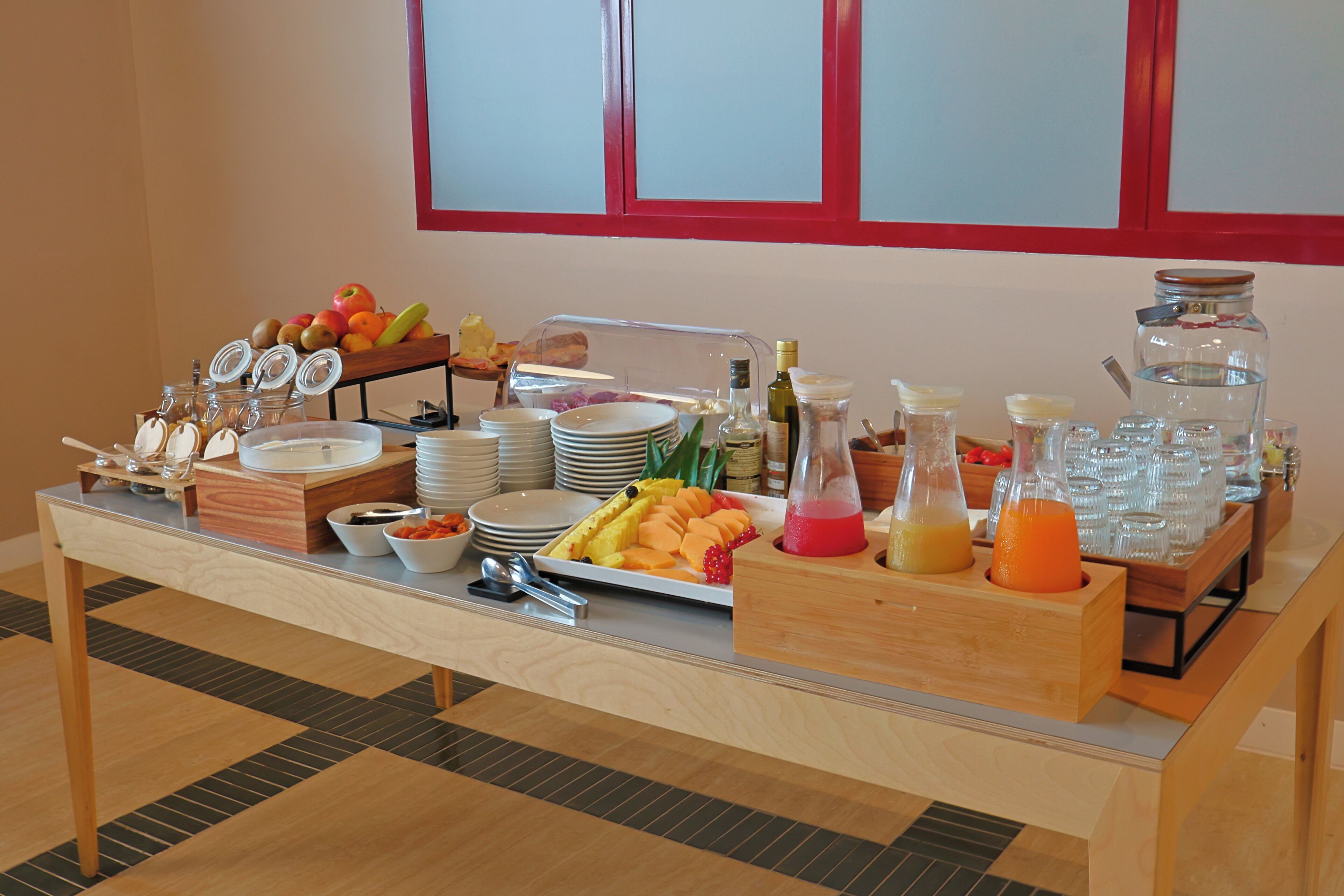 A buffet table with various food items, plates, and condiments.