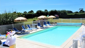 En pool med solstolar och parasoller.