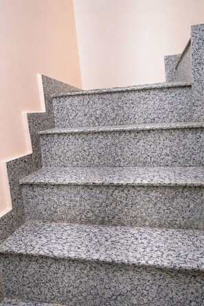 A set of granite stairs with a handrail, leading to an upper floor. - Kashika Paying Guest House (Varanasi)