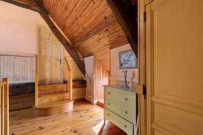 A room with wooden floors, a staircase, a dresser, and a door. - Gîte Grange – La Mare Chappey, child-friendly, heated pool (Néhou)