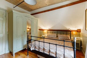 Un dormitorio con cama, mesitas de noche, armario y lámpara de techo.