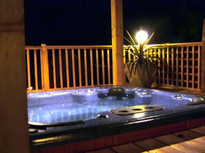 Ein Whirlpool mit Holzterrasse und einem Topfpflanzen.