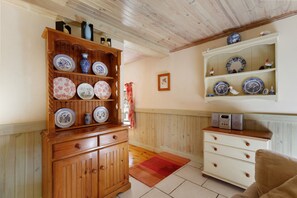 A room with wooden cabinets, a white dresser, and shelves with decorative plates. - Riverside Gîte – La Mare Chappey, Family-Friendly, Heated Pool (Néhou)