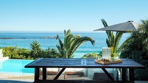 A wooden table with a drink tray, overlooking a pool and ocean view. - Camps Bay 6bed w Ocean Views and Pool Villa Sevara (Cape Town)