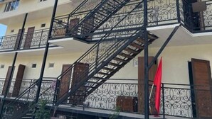 Een meerhoog gebouw met een bord dat een kamerindeling van 2 bij 3 bij 4 aangeeft en een naam die doet denken aan een hotel of vergelijkbare accommodatie.