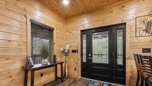 A wooden interior with a black door, a bench, a vase, and a welcome mat. - Minutes from Pigeon Forge - NEW 5 Bed/5Bath Rental - Slps 12 (Pigeon Forge)