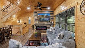 A wooden interior with a TV, sofa, and staircase. - Minutes from Pigeon Forge - NEW 5 Bed/5Bath Rental - Slps 12 (Pigeon Forge)