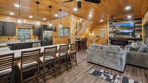 A wooden interior with a kitchen, dining area, and living room. - Minutes from Pigeon Forge - NEW 5 Bed/5Bath Rental - Slps 12 (Pigeon Forge)