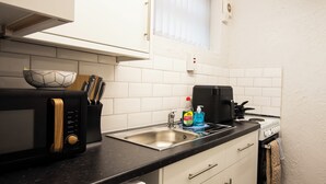 A compact kitchen with a microwave, a coffee maker, and a sink. - St Andrews By Guestz (Lytham Saint Annes)
