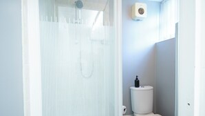 A bathroom with a shower enclosure, toilet, and a wall-mounted air purifier. - St Andrews By Guestz (Lytham Saint Annes)