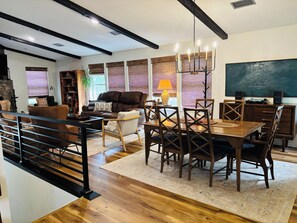 Ein modernes Wohnzimmer mit Essbereich, Holzboden und einer Treppe.