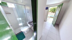 A narrow bathroom with a shower, toilet, and sink. - Pousada Suites de Porto (Ipojuca)