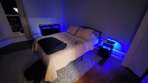 Ein Schlafzimmer mit einem Bett, Nachttischen und einem Beistelltisch.