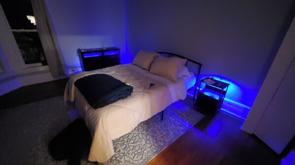 A bedroom with a bed, bedside tables, and a nightstand.