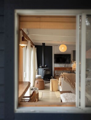 Ein gemütliches Wohnzimmer mit Kamin, Fernseher und bequemen Sitzmöglichkeiten.