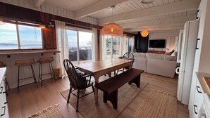 Amplia sala de estar con mesa de comedor de madera, sofá y televisor.