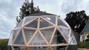 Estructura en forma de cúpula geodésica con un jacuzzi en primer plano.