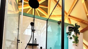 Un baño moderno con cabina de ducha de vidrio, inodoro y calentador de agua.