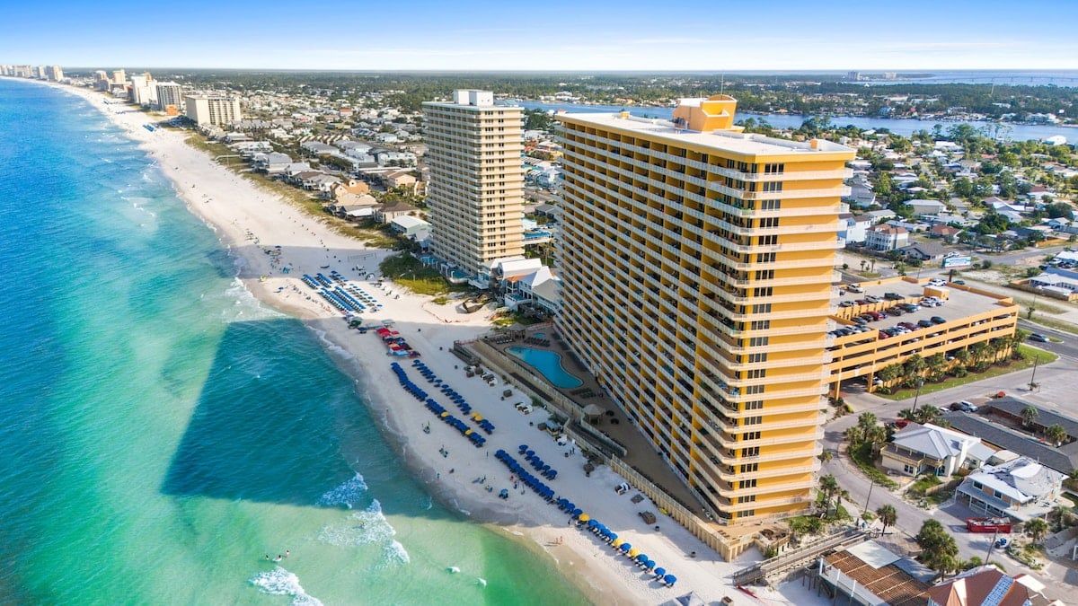 Ein Hotel direkt am Strand mit mehreren Etagen und einem Poolbereich.