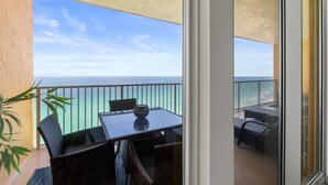 Ein Balkon mit Tisch und Stühlen, Blick auf das Meer und eine Pflanze.