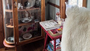 A wooden cabinet with glass doors containing various items. - Tiny Timber frame 1-bedroom cabin in Candor with AC/Heat, Outdoor fire and tub. (Candor)