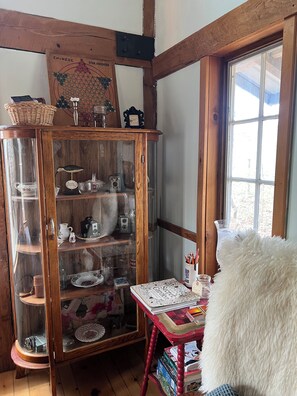 A wooden cabinet with glass doors containing various items.