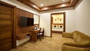 A room with a wooden desk, chair, television, and a sofa. - GOLDEN STAR (Kollam)