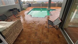 A rooftop patio with a swimming pool, a covered seating area, and a view of the cityscape. - Room-a Peaceful and Scenic Area Designed (Cape Town)
