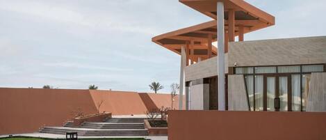 A modern building with a unique architectural design, featuring a prominent overhanging structure and a staircase leading to an entrance.