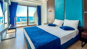 A hotel room with a large bed, a desk, and a view of the sea. - Hitit Marina Hotel & Bungalows (Alanya)