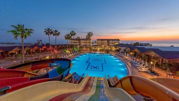 A resort with a large swimming pool, multiple slides, and beachfront villas. - Hitit Marina Hotel & Bungalows (Alanya)