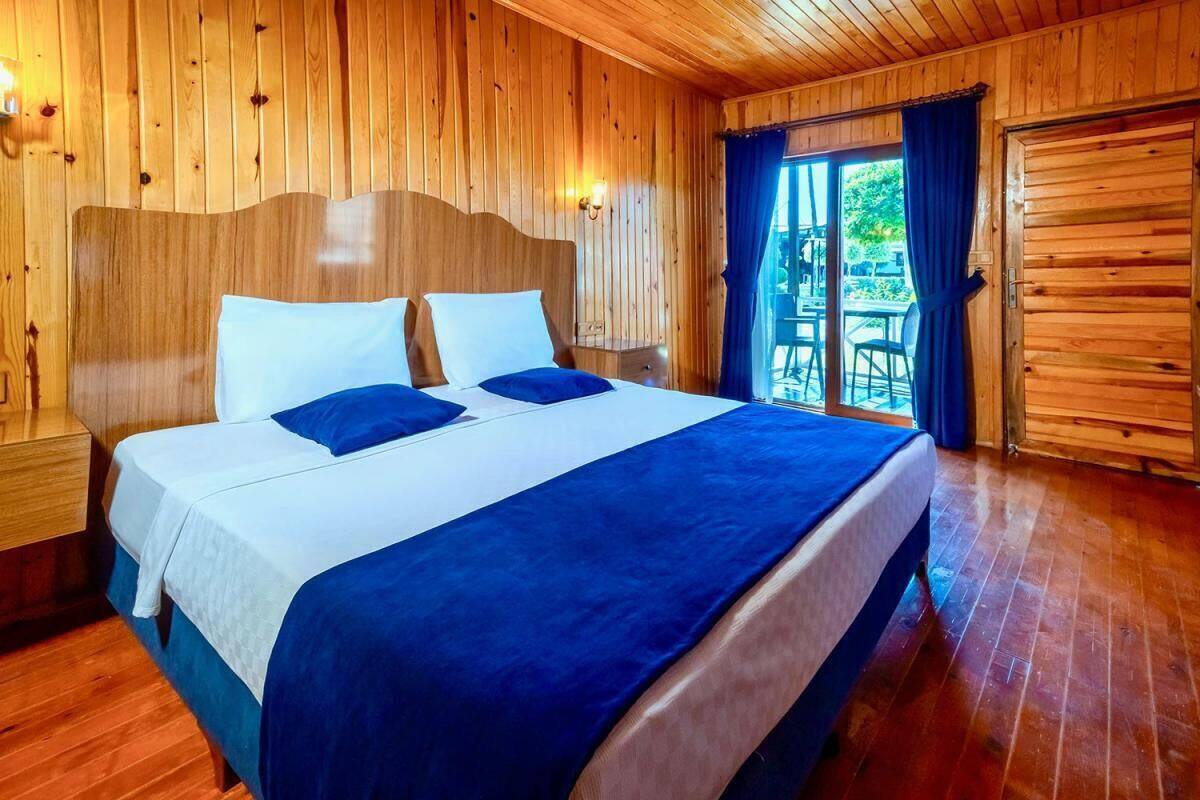 Una habitación con paneles de madera, una cama y un cabecero de madera, además de una puerta corredera que da a un espacio exterior.