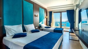 A hotel room with two beds, a TV, a balcony with a view of the sea, and a large window. - Hitit Marina Hotel & Bungalows (Alanya)