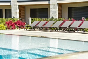 Una piscina al aire libre de temporada, sombrillas